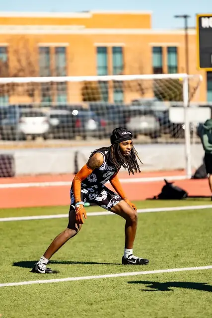 Athlete in a black uniform preparing on a sunny football field