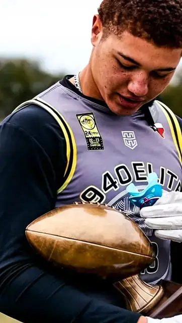 Athlete holding a football and looking down at it
